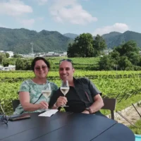 Two guests drinking white wine beside vineyards and mountains at Katsunuma Jyozo in Yamanashi