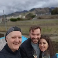 Morey and two guests holding glasses of Koshu sparkling wine above vineyards in Yamanashi
